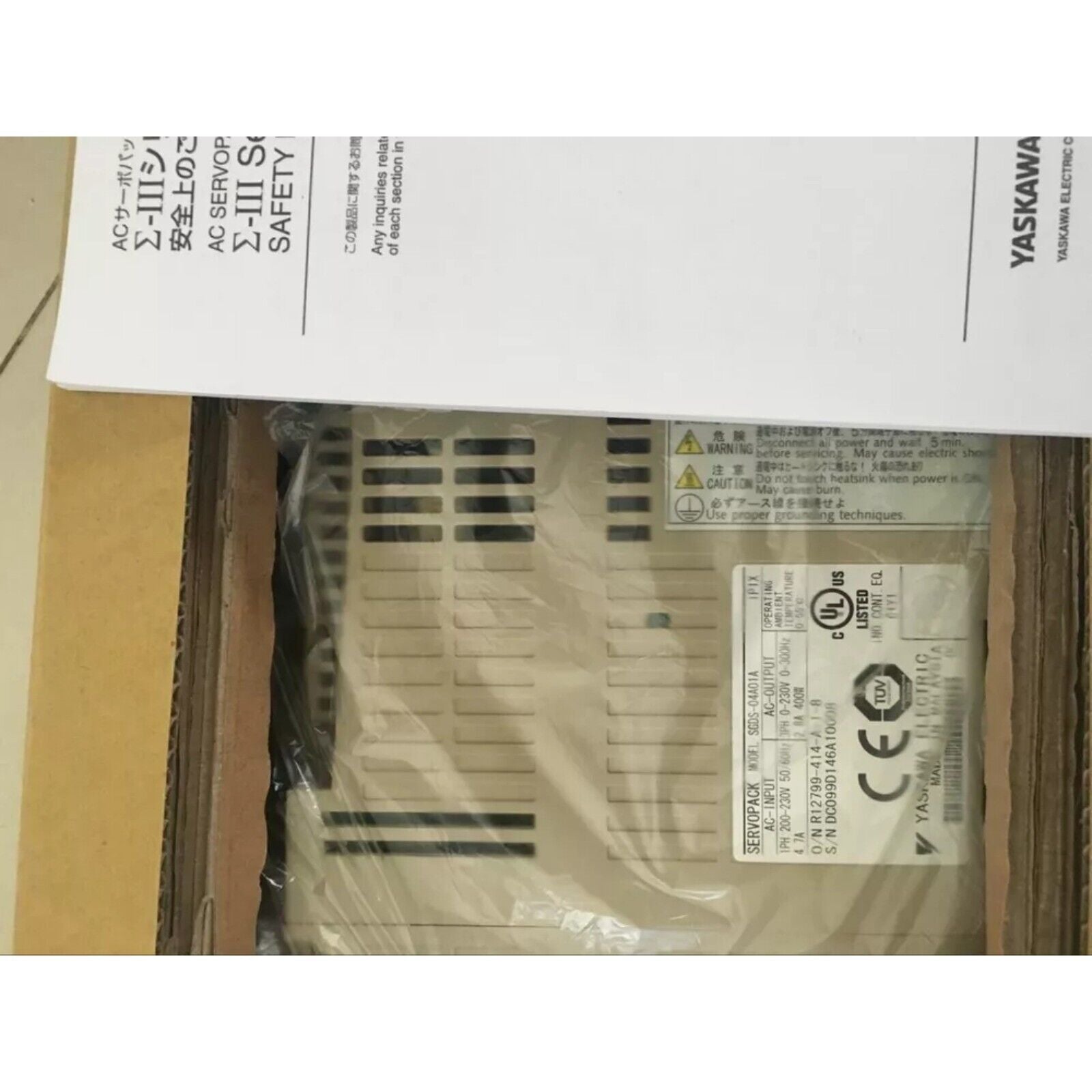 Yaskawa SGDV-04A01A servo drive, beige industrial automation component, safety information and product label visible