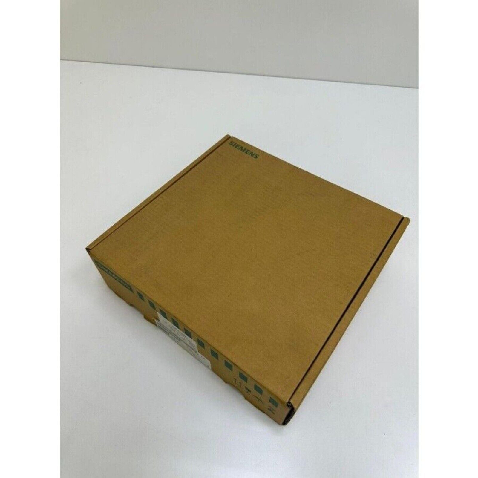 Siemens SINUMERIK industrial part packaging box, brown cardboard, Siemens logo visible.