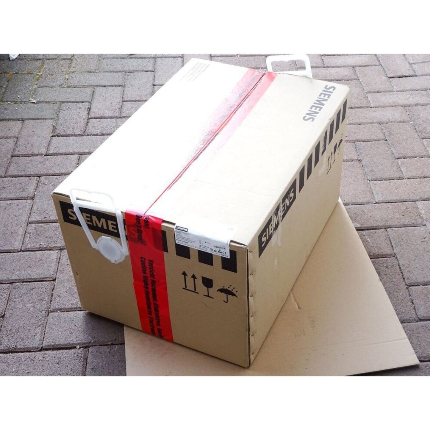Siemens industrial automation part packaging, fragile with handle, red tape caution, product delivery.