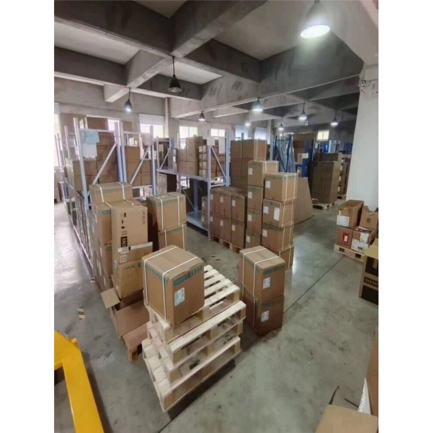 Warehouse stock of Siemens PLC Power Blocks on pallets ready for shipment, industrial automation parts.