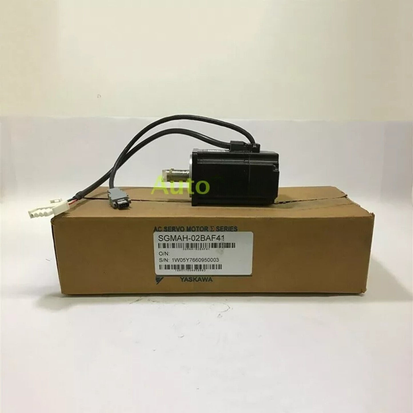 YASKAWA ELECTRIC SGMAH-02BAF41 Servo Motor, black, on a cardboard box. Industrial automation part.