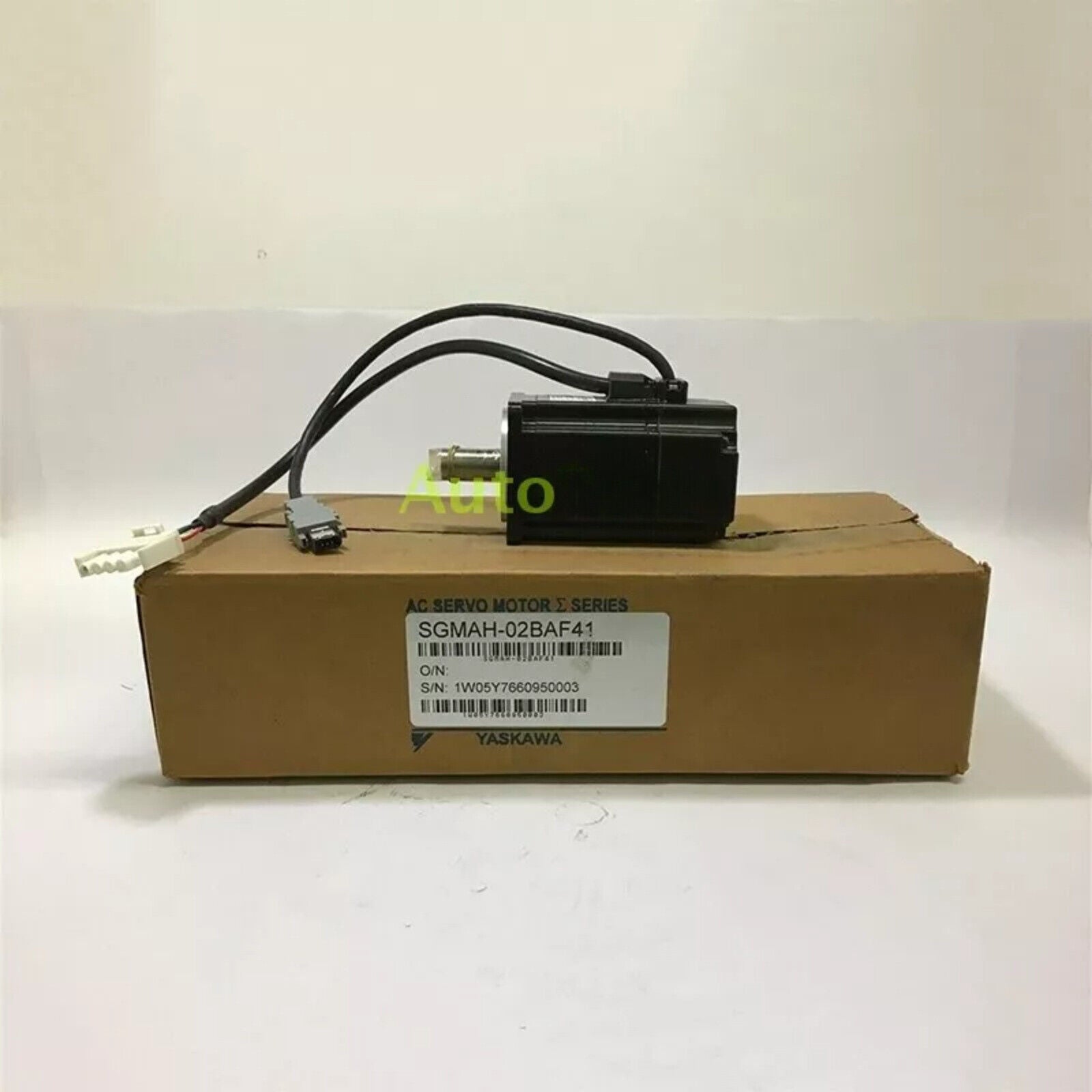 YASKAWA ELECTRIC SGMAH-02BAF41 Servo Motor, black, on a cardboard box. Industrial automation part.