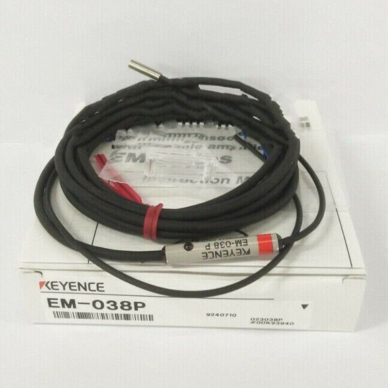 KEYENCE EM-038P Proximity Sensor in box. The sensor is black, with a silver tip and red detailing, coiled on top of the box.