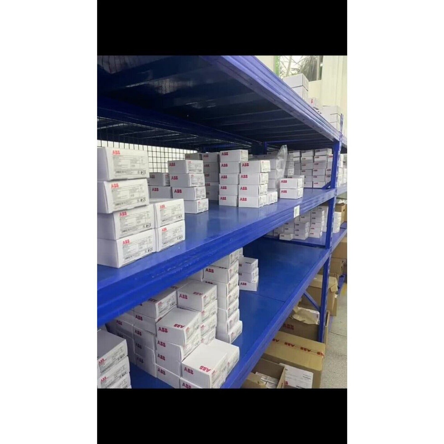 ABB industrial automation parts inventory on blue shelving, industrial automation equipment.
