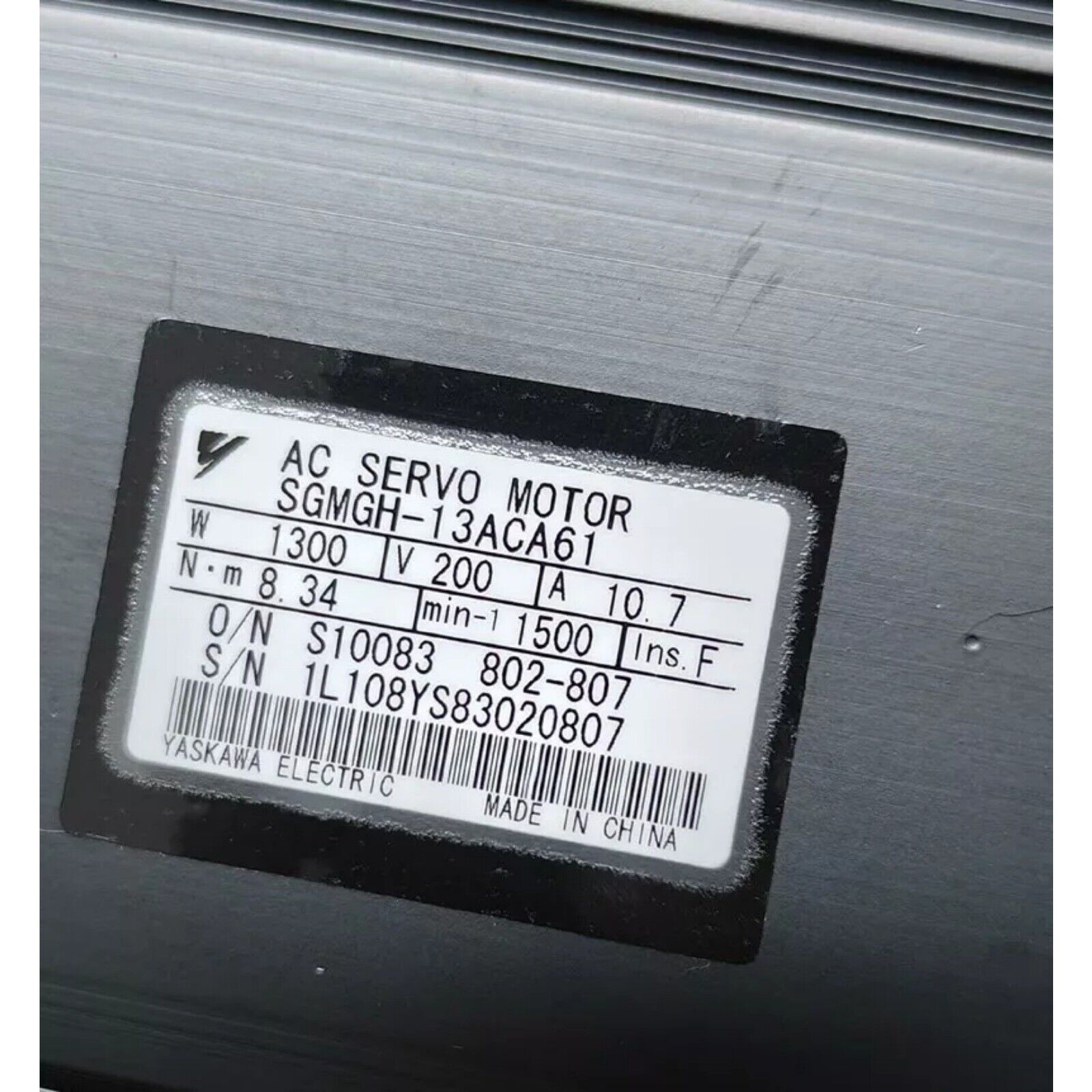 Yaskawa SGMGH-13ACA61 servo motor label. Made in China. Specs: 1300W, 200V, 10.7A. Industrial automation spare.