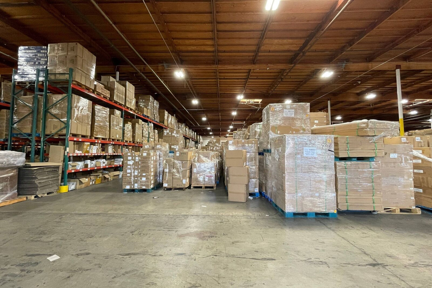 Warehouse with stacked boxes on pallets and shelves, ready for shipping