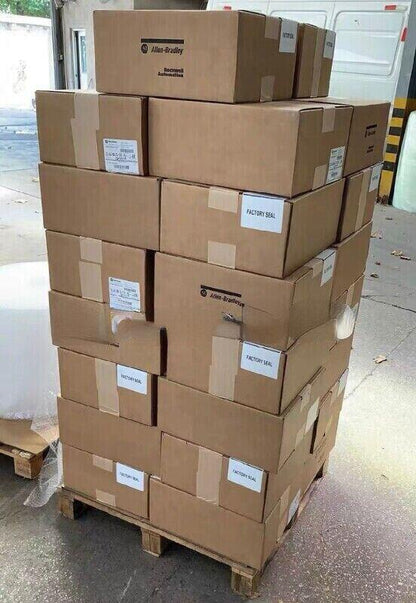 Stacked Allen-Bradley PowerFlex 70 drive boxes on pallet, factory sealed for industrial automation parts.