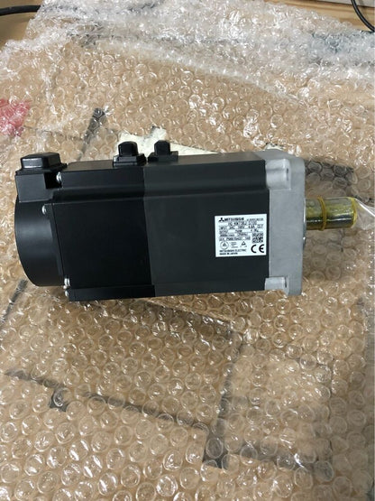 Mitsubishi HG-KN73BJ-S100 AC servo motor in bubble wrap. Industrial automation part, made in Japan.