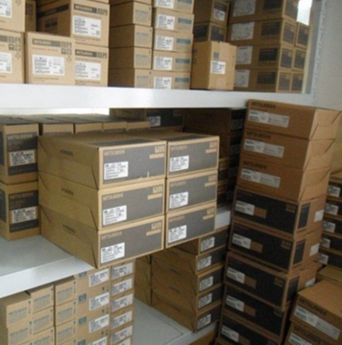 Mitsubishi MR-J4-700A4 Servo Drive boxes stacked in warehouse, industrial automation components.