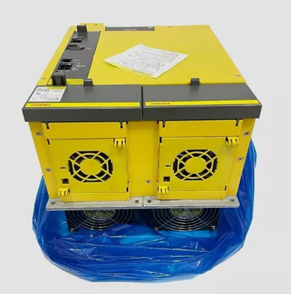 FANUC A06B-6110-H055 servo drive amplifier, yellow with gray accents, cooling fans, and documentation.