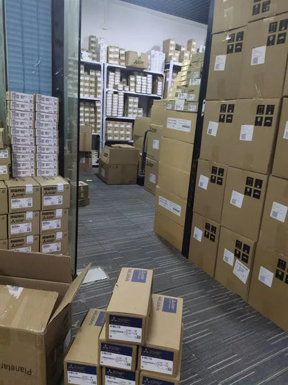 Warehouse stock of Mitsubishi FX3G-40MT/ES PLC modules in boxes, ready for fast shipping.
