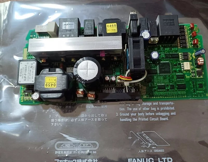 FANUC A20B-2101-0390 control board, green circuit board with labels and components, static protective bag, PLC spare parts.