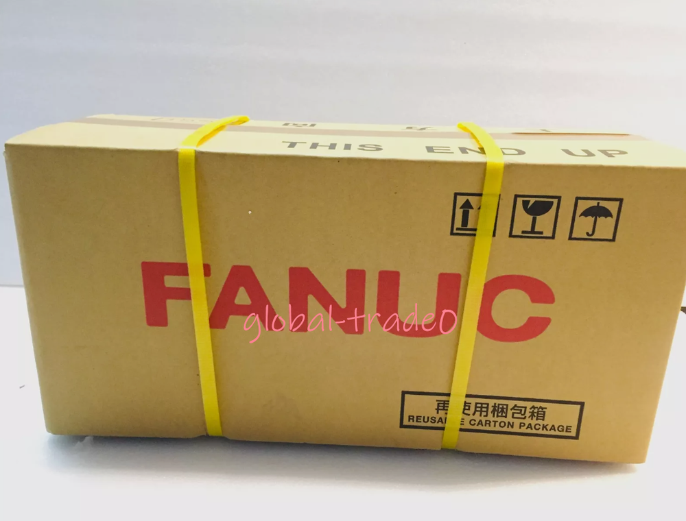 FANUC servo motor in carton packaging, industrial automation part, carton with 'THIS END UP' mark.
