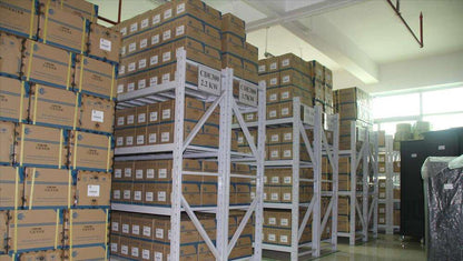 Warehouse storage of CDE300 products, stacked boxes on metal shelving. 2.2kW and 3.7kW models.