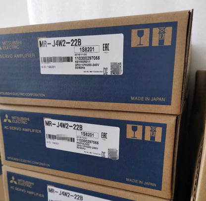 Mitsubishi MR-J4W2-22B AC Servo Drive boxes, featuring product labels with serial numbers, manufactured in Japan.