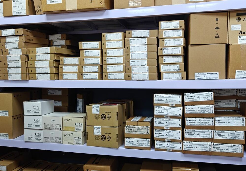 Industrial automation parts inventory on shelves, featuring Allen-Bradley product boxes.