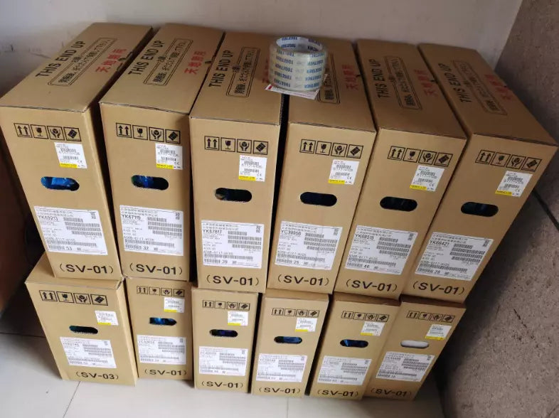 FANUC A06B-6114-H207 servo drive shipping boxes, "THIS END UP" labels. Industrial automation components.