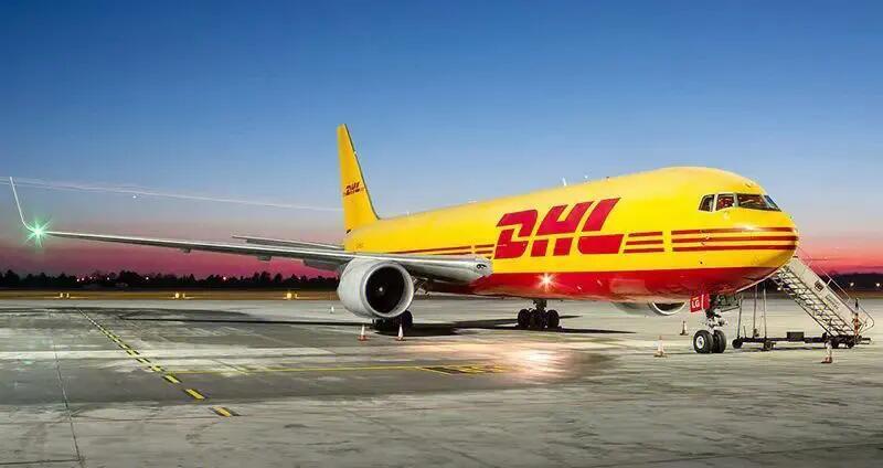 DHL cargo plane on the runway, transporting industrial automation parts, yellow and red livery.