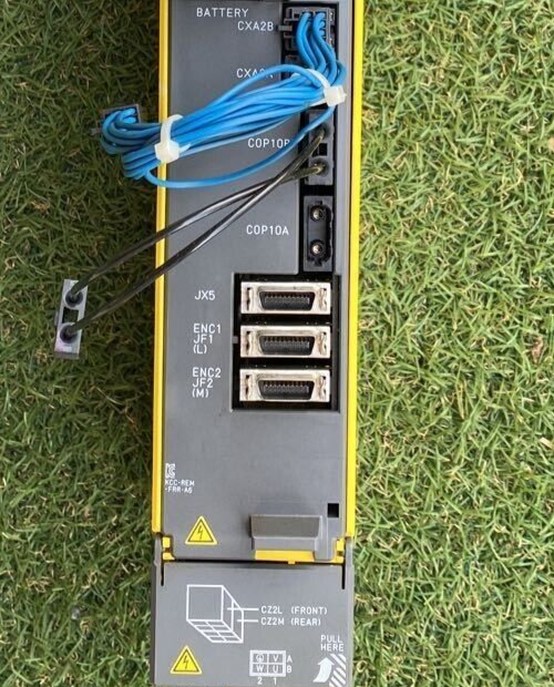 FANUC A06B-6117-H205 Servo Amplifier rear view with connectors, cabling and warning signs, removed from a working machine.