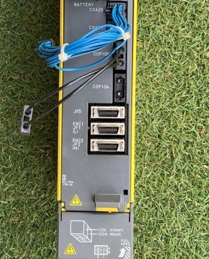 FANUC A06B-6117-H205 Servo Amplifier rear view with connectors, cabling and warning signs, removed from a working machine.