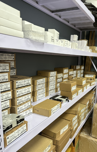 Allen-Bradley PLC parts inventory in boxes on shelves, industrial automation components.