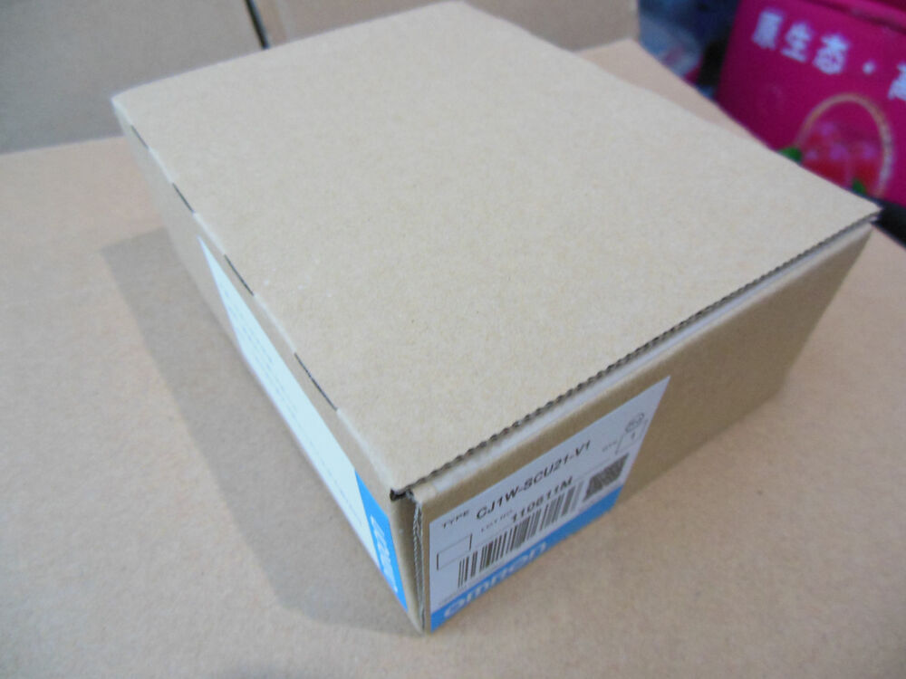 Omron CJ1W-SCU31-V1 PLC Module in its original cardboard box, featuring product label and barcode.