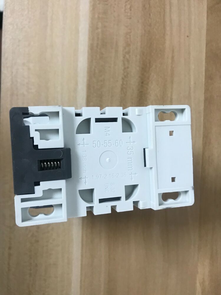 ABB N22E contactor relay, top view of white plastic component with measurements and labels on a wooden surface.