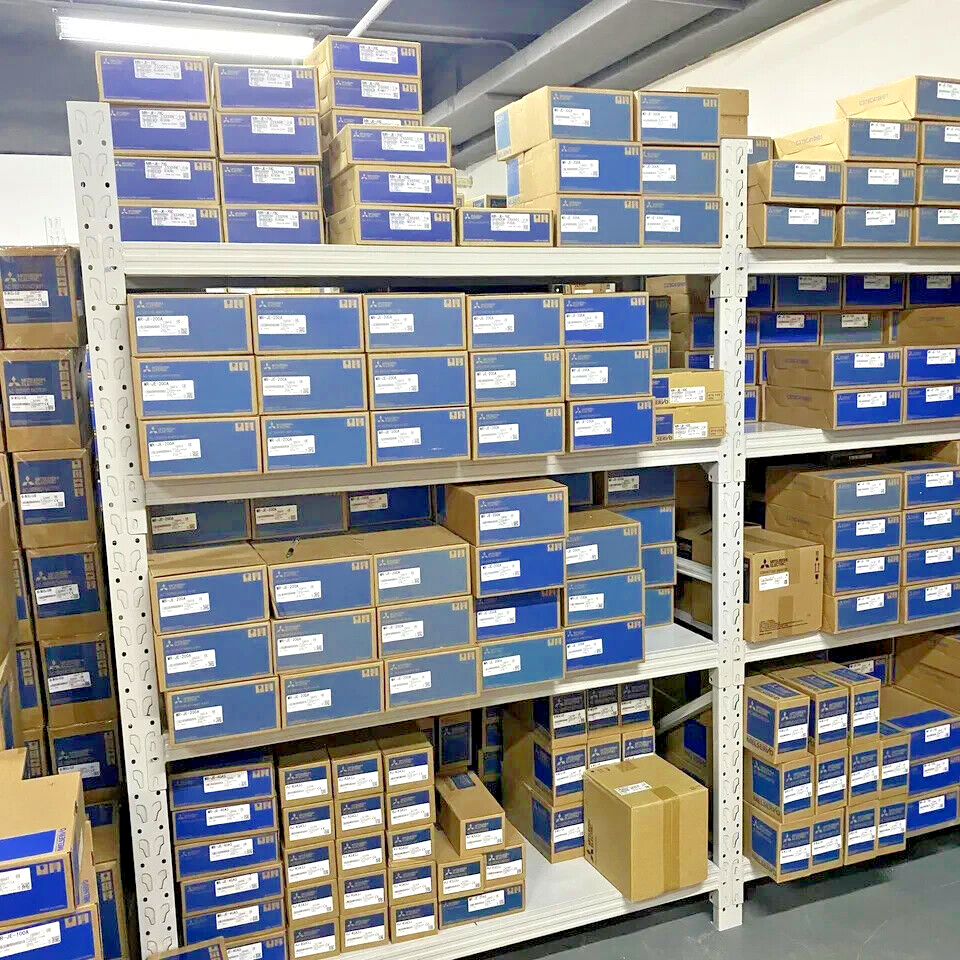 Mitsubishi MR-J3-20BS AC Servo Drives in boxes stacked on warehouse shelves, new in box.