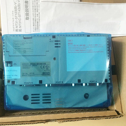 New Omron NT31C-ST143-V3 HMI panel in box with Japanese documentation, showing connection ports and safety instructions.