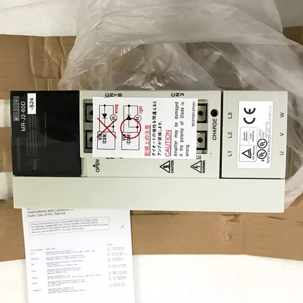 Mitsubishi MR-J2-60D-S24 Servo Drive, new in box, with warning labels and connection diagrams.