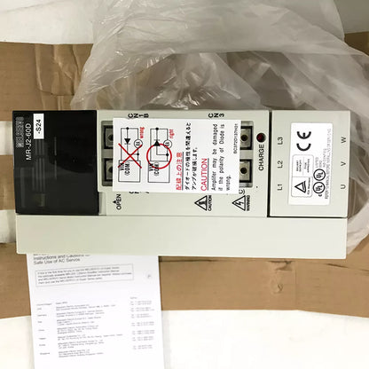 Mitsubishi MR-J2-60D-S24 Servo Drive, new in box, with warning labels and connection diagrams.