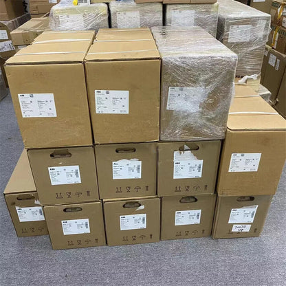 Stacked ABB ACS880-01-105A-3 frequency converter boxes, new in stock, ready for dispatch, with shipping label.