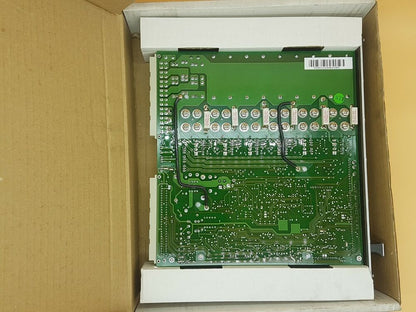 ABB AXODYN DKH-E 2601 servo drive circuit board in box. Green PCB with electronic components, industrial automation part.