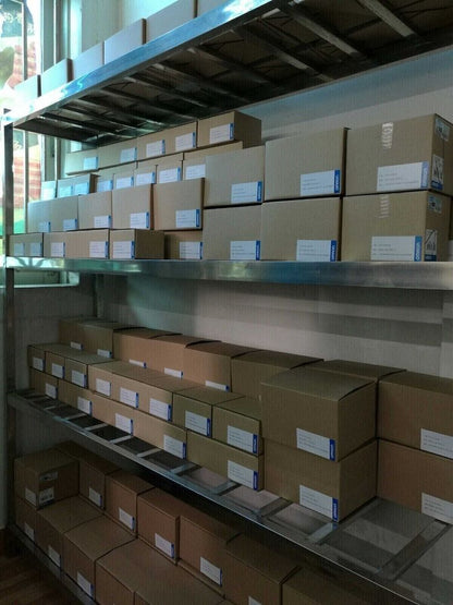 Omron CJ1W-IA201 Input Unit PLC Modules in boxes, stored on shelves. New in box with OMRON labels.