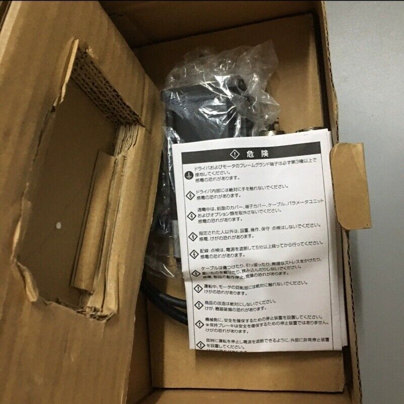 Omron R7M-A40030-S1-D servo motor in opened box, industrial automation part, with warning document.