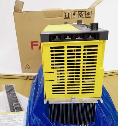 FANUC A06B-6110-H055 servo drive amplifier, yellow and black in box. Industrial automation part.