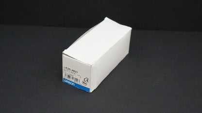 Omron E3S-AD31 sensor box. White cardboard packaging with model info, Omron logo, and certifications.