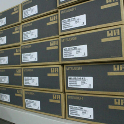Mitsubishi servo motor boxes stacked, MR-J2S-70B and MR-J2S-70B-EB labels visible, industrial automation parts.