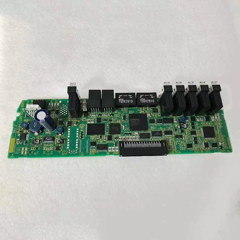 FANUC A20B-2102-0671 circuit board. Green PCB with electronic components, PLC module for industrial automation.