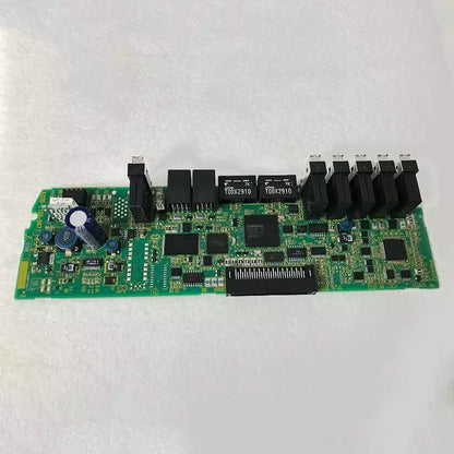 FANUC A20B-2102-0671 circuit board. Green PCB with electronic components, PLC module for industrial automation.