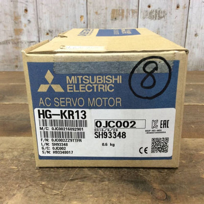 Mitsubishi HG-KR13 AC Servo Motor box on wooden surface, featuring product details and serial numbers.