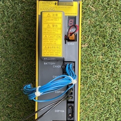 FANUC Servo Amplifier A06B-6117-H205, featuring warnings, connectors, and cabling details.