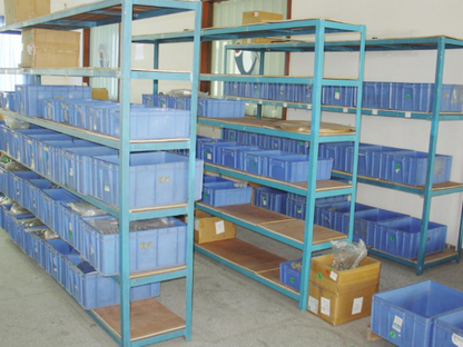Warehouse with ABB PLC and disconnector parts, blue bins on shelving, ready for industrial automation.