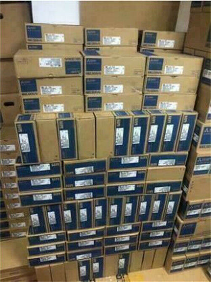 Mitsubishi MR-J4-700A4 Servo Drive boxes stacked in a warehouse, industrial automation components, DHL shipping.