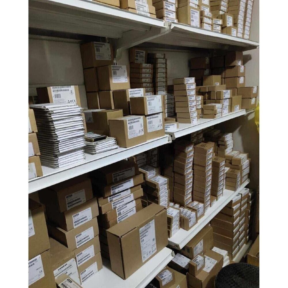 Warehouse stock of industrial automation parts, including Siemens boxes and other components on shelves.