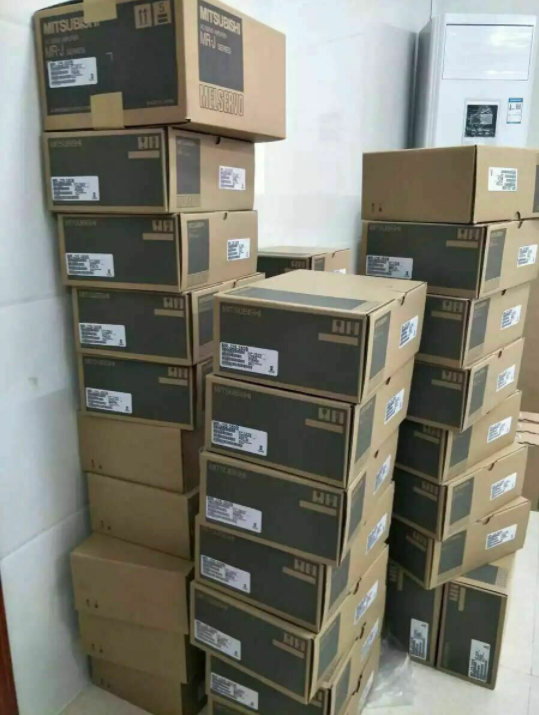 Mitsubishi HC353S servo motor boxes stacked for shipping, Melservo packaging, industrial automation parts.