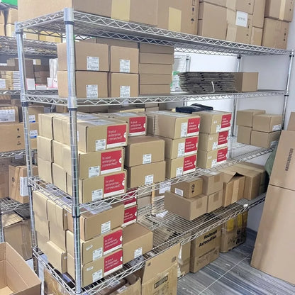 Warehouse of Allen-Bradley PLC modules in boxes, 'Is your enterprise connected?' labels, Rockwell Automation.