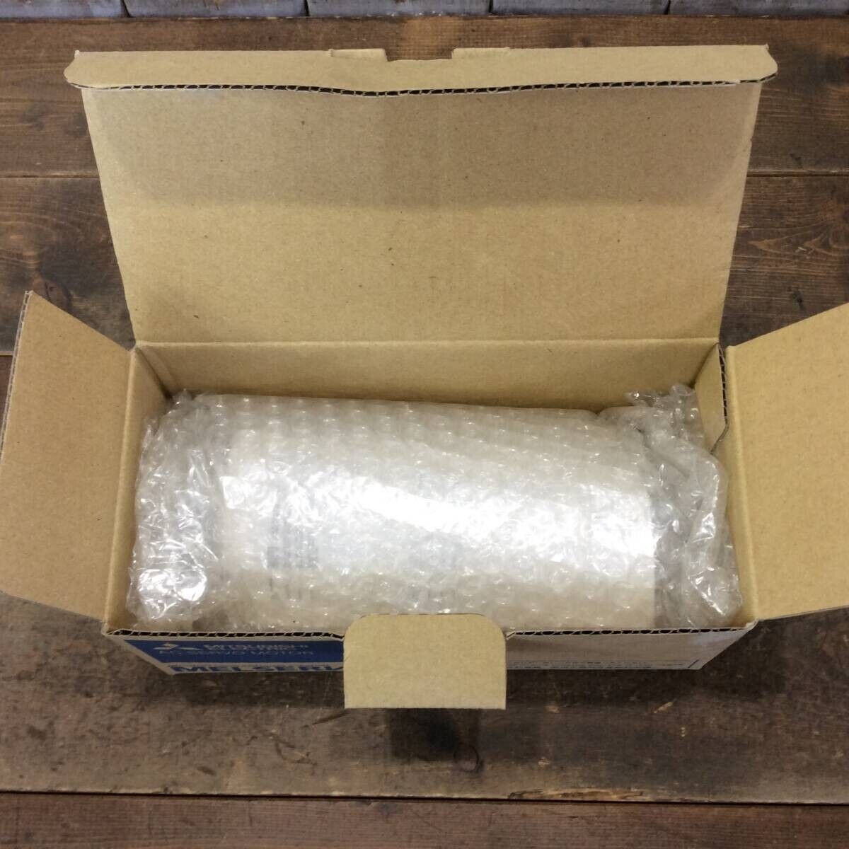 Mitsubishi HG-KR13 Servo Motor in its original packaging, bubble wrapped inside a cardboard box.