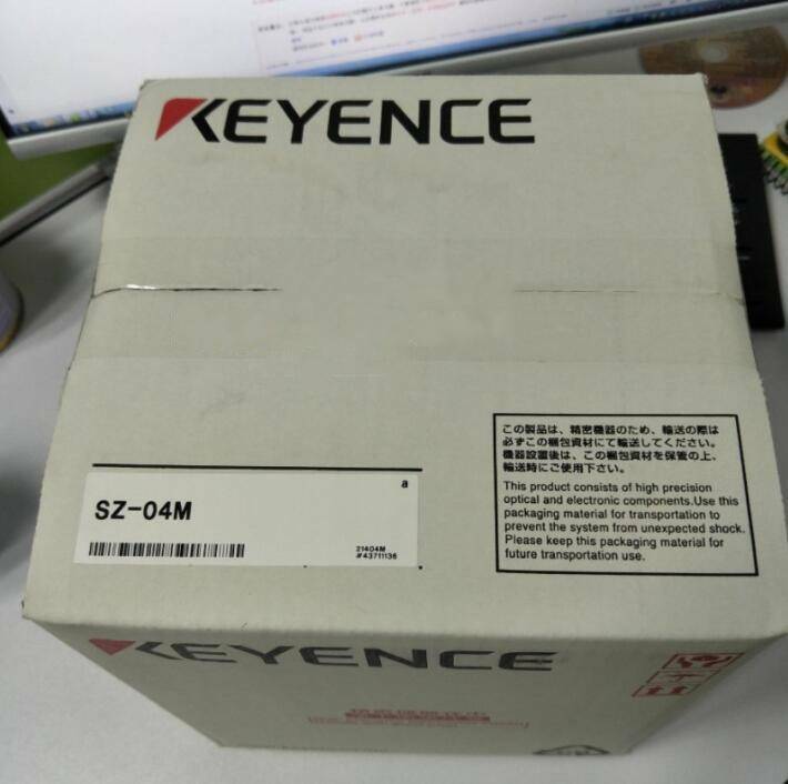 Keyence SZ-04M Laser Scanner packaging box, white cardboard with product information and warnings.