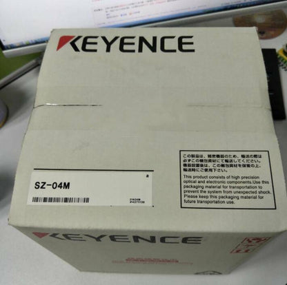 Keyence SZ-04M Laser Scanner packaging box, white cardboard with product information and warnings.